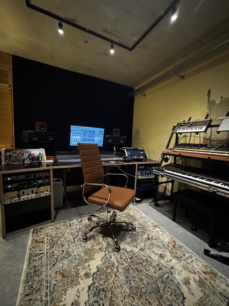 Weitwinkel-Ansicht des Regieraums mit Synthesizern